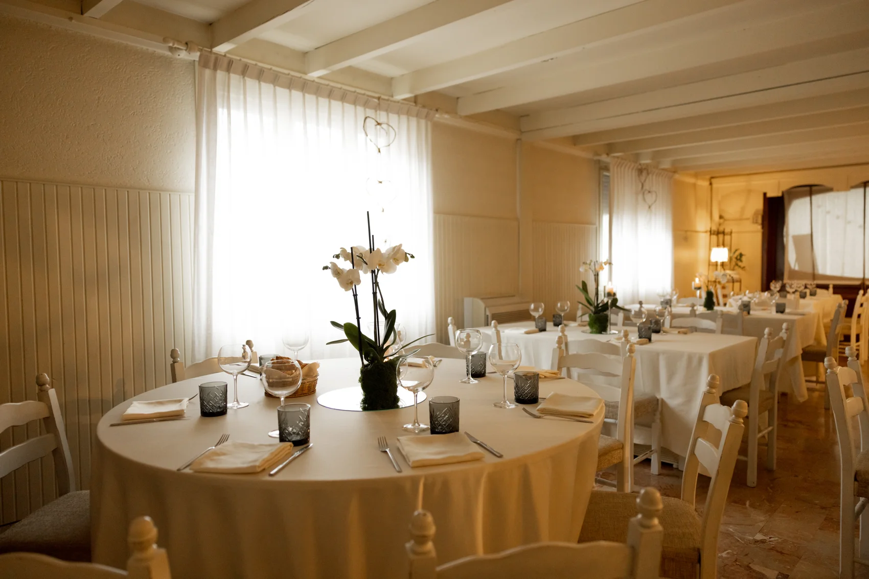 La sala luminosa di Ristorante Bianchi, con tavoli apparecchiati e fiori freschi